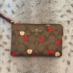 Coach brown leather wristlet with red apple print